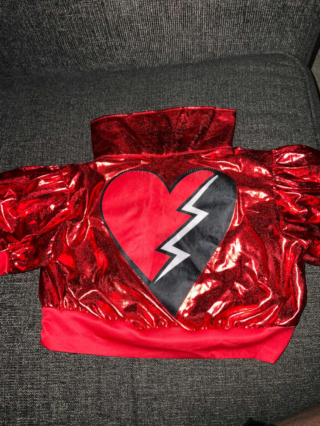 Back view of metallic red bomber jacket with broken heart lightning bolt graphic