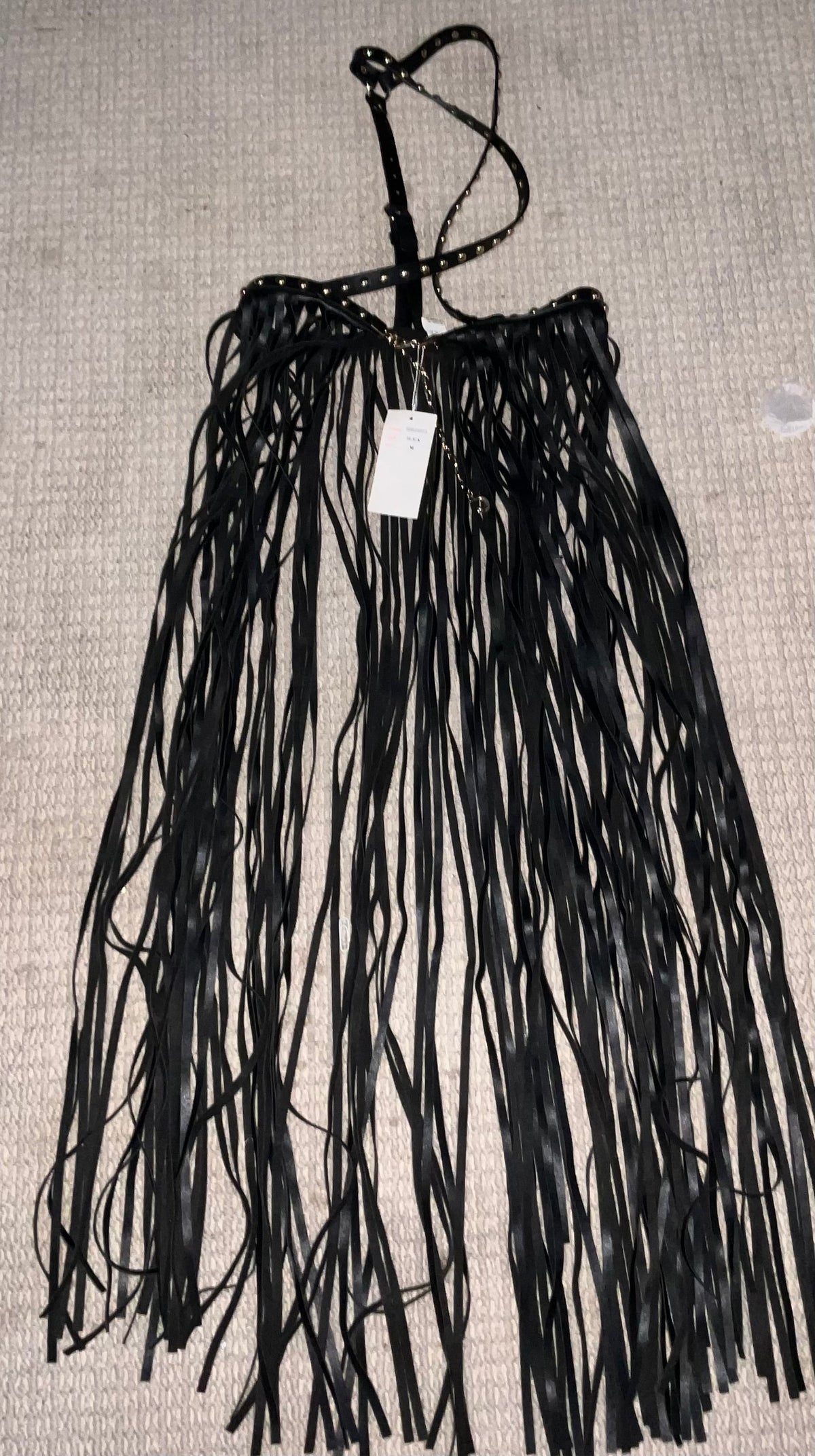 Black faux leather fringe halter top with silver studded trim and crossback halter strap laid flat