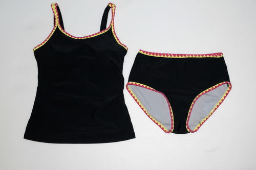 Black two-piece tankini swimsuit with pink and yellow zigzag trim on clean white background